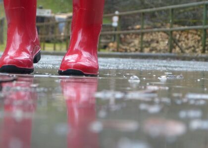 red wellington boots on a rainy pavement